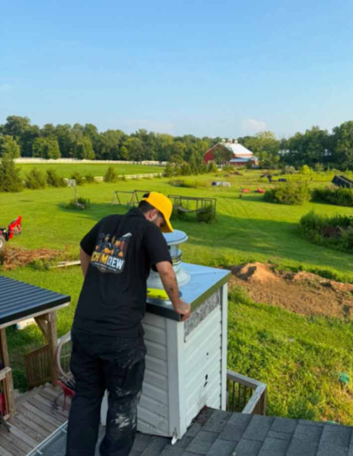 ChimCrew technician installing a stainless steel chimney cap