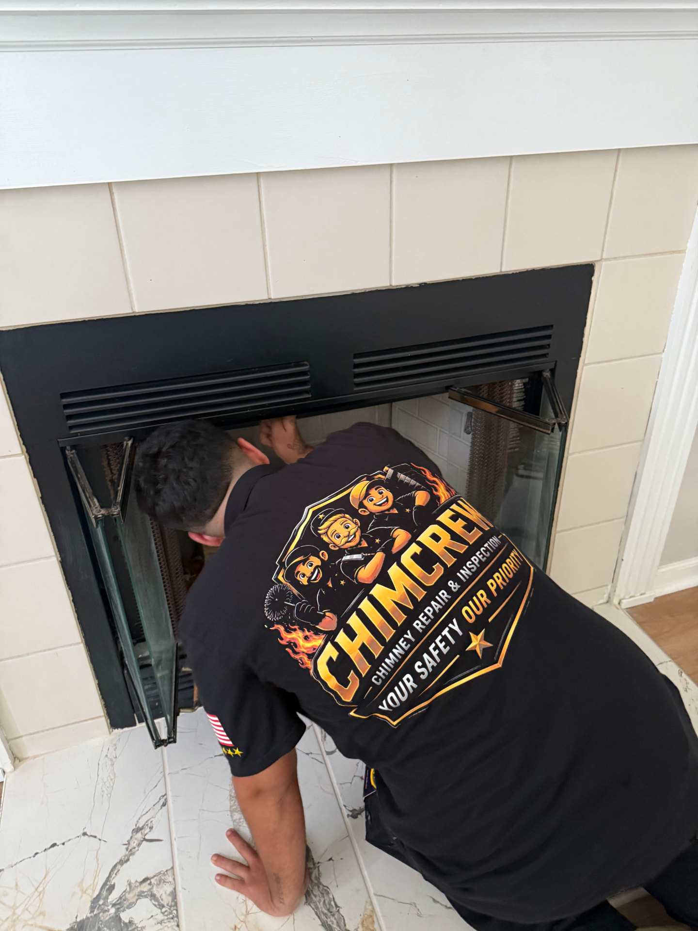 ChimCrew technician sweeping and cleaning a fireplace firebox