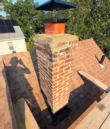 Rebuilt brick chimney with new clay flue tiles and rain cap
